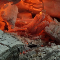Foto van gloeiend houtskool voor de workshop vuurlopen.